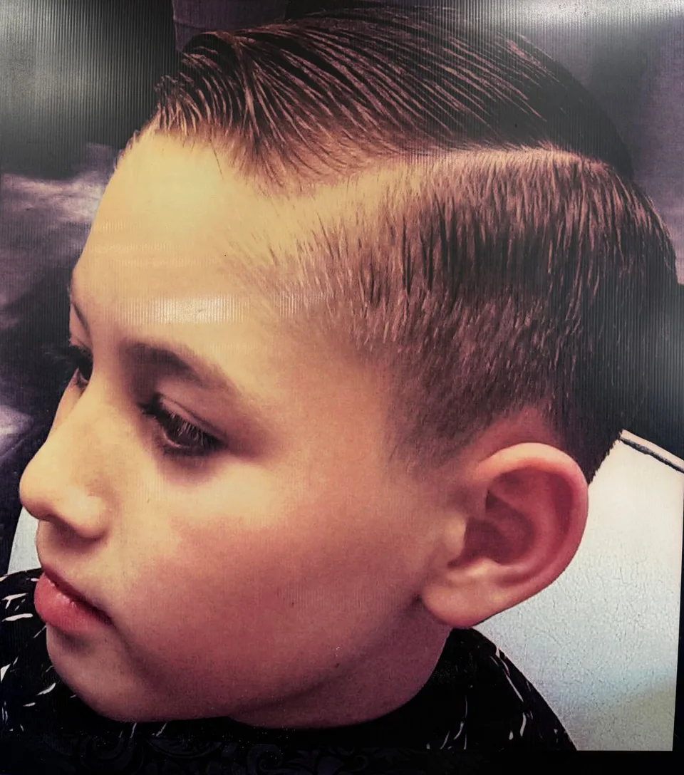 A boy's classic side-part cut with a tapered side