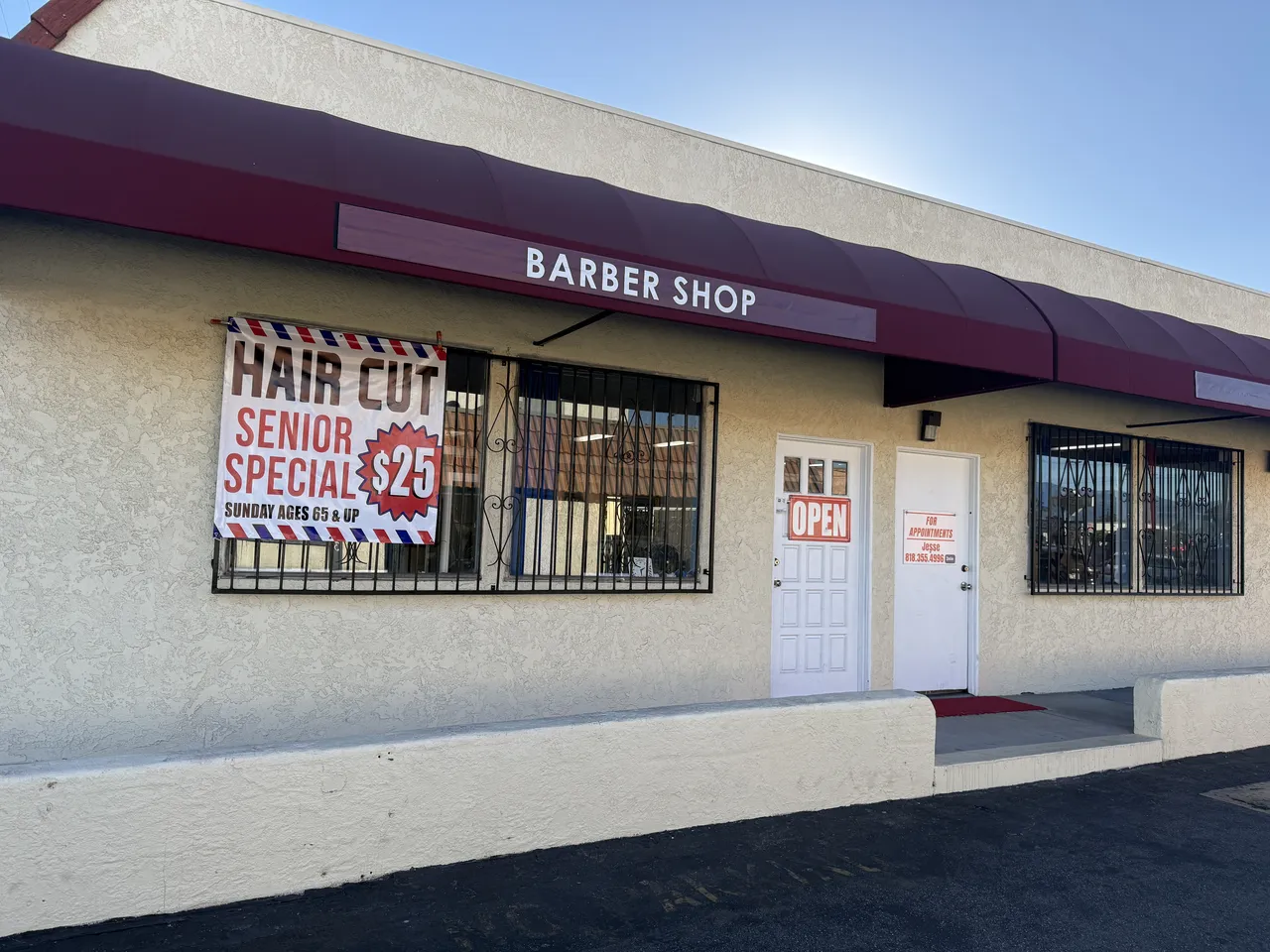 The J&J Barber Shop storefront on Osborne Street, with the Senior Special banner in the window